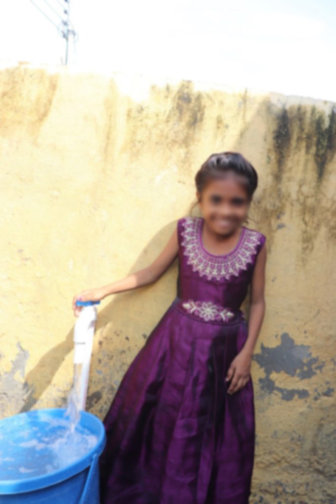 girl in front of safe water tap